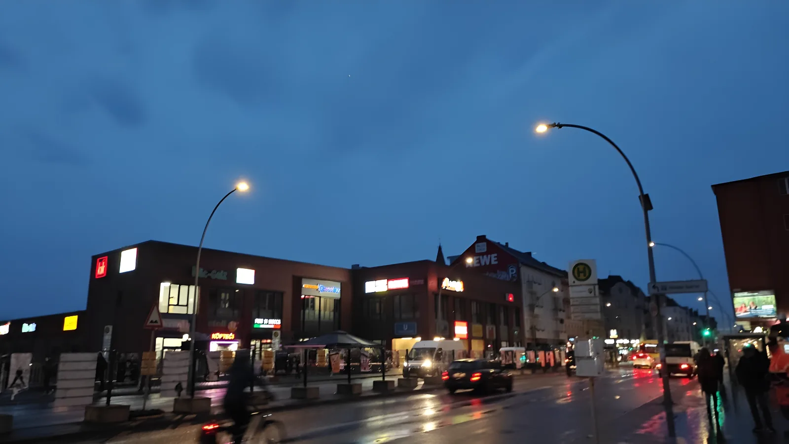 A dark city intersection with car taillights